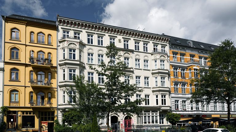 Historische Berliner Altbaufassaden mit Bäumen im Vordergrund.